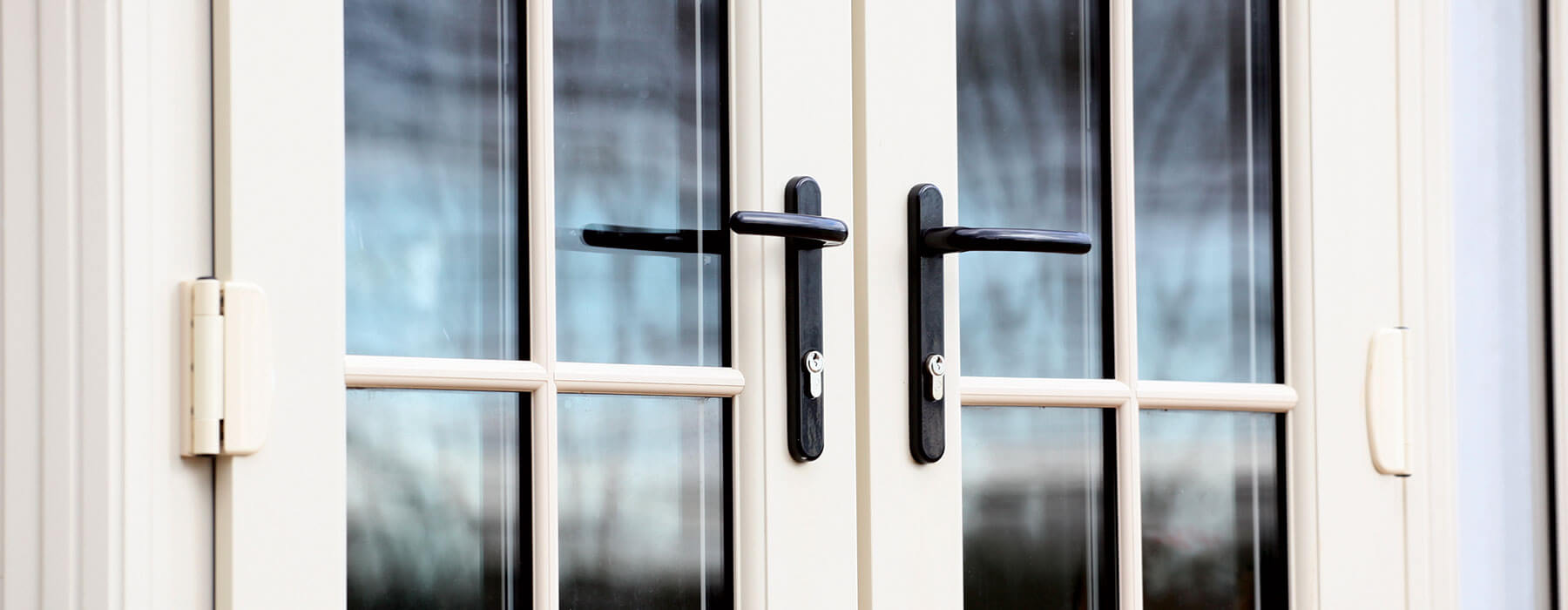 close up external shot of white french doors with black handles