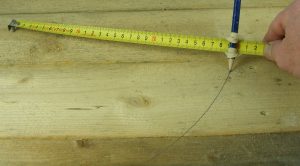 shot of measuring tape and marking with pencil on wood